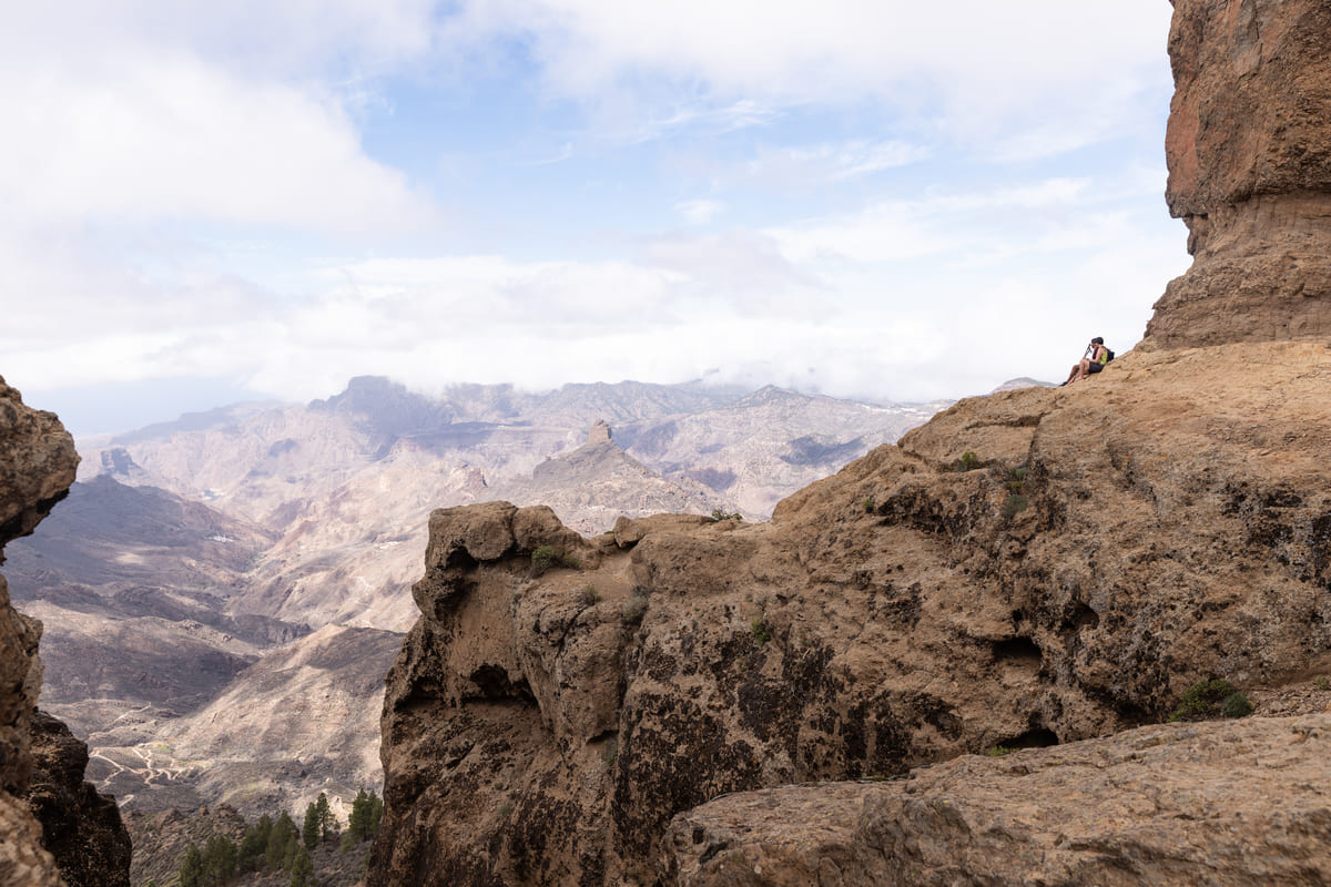 Dos senderistas recostados en la base de Roque Nublo. Fotografía: Júlia Miralles Larrègola